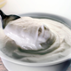 Spoon being dipped into bowl of Greek yogurt